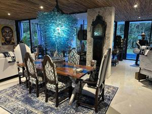 a dining room with a table and chairs and a chandelier at Casa Azul-Xpuha, Tulum, Mexico in Xpu Ha