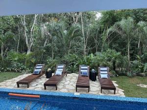 a group of chairs sitting next to a swimming pool at Casa Azul-Xpuha, Tulum, Mexico in Xpu Ha