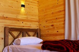 a bedroom with a bed with a wooden wall at Dagal Camp - دجل كامب in Sharm El Sheikh