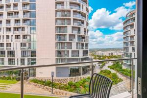 a balcony with a chair and some tall buildings at Solitude Studio Apartment, Ellipse, Midrand in Midrand