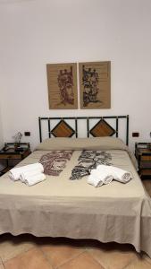a bed with two white towels on top of it at Hotel Principe di Rinella in Leni