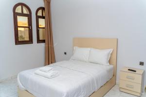 a bedroom with a white bed and a mirror at Erraha Hostel Dakhla in Dakhla +19 photos