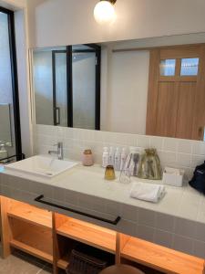 a bathroom counter with a sink and a mirror at Love&Peace Resort in Shima +38 photos