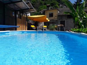 an umbrella and a chair in a swimming pool at Barolo in Gravedona