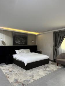 a bedroom with a large bed and a chair at استراحة ريف حتا in Hatta +33 photos