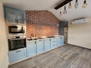 a kitchen with blue cabinets and a brick wall at استراحة ريف حتا in Hatta
