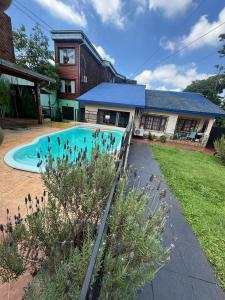 a swimming pool in front of a house at Hotel Los Lapachos in Puerto Iguazú