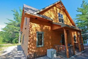 a tiny house with a wrap around porch at Whitewater Cottage & RV Resort in Foresters Falls