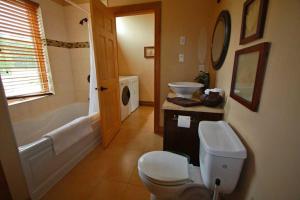 a bathroom with a toilet and a tub and a sink at Whitewater Cottage & RV Resort in Foresters Falls +24 photos