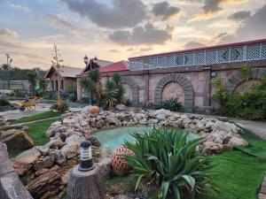 a garden with a small pool of water in front of a building at استراحة ريف حتا in Hatta