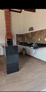 a living room with a counter and a brick fireplace at JMS Refuge in Pirapora +4 photos
