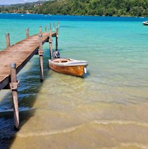 a boat parked next to a wooden pier at Le Joyau du lac in Charavines
