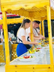 a group of people preparing food at a buffet at Elite Rum Camp in Disah