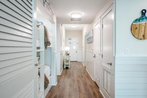 a hallway of a home with white walls and wood floors at Ocean Blue at 1805 Aqua in Panama City Beach +28 photos