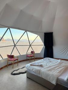 a bedroom with two chairs and a bed in a tent at Elite Rum Camp in Disah