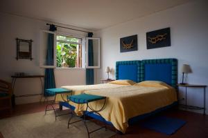 a bedroom with a bed and two blue chairs at Faja dos Padres in Ribeira Brava
