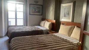 a hotel room with two beds and a window at Hotel Santo Domingo in Zacatecas +3 photos