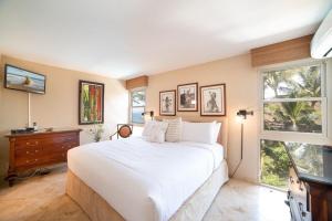 a bedroom with a large white bed and windows at Nani Kai Hale 308 in Kihei +42 photos