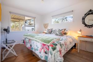 a bedroom with a bed and a desk and two windows at Clarendon Cottage, near Lowood , Fernvale, right on the BVRT in Clarendon