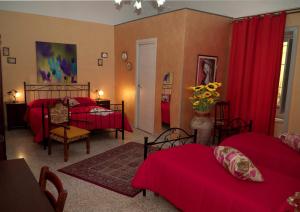 a bedroom with two beds and red curtains at B&B L'Angelica in Piazza Armerina