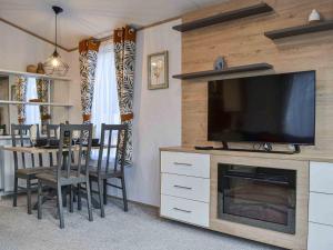 a living room with a television and a table with chairs at Willow - Uk36374 in Westward