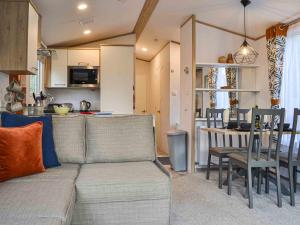 a living room and kitchen with a couch and a table at Willow - Uk36374 in Westward