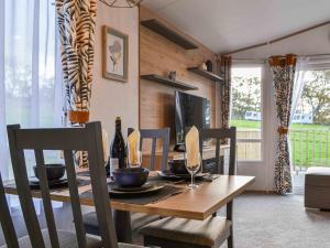 a dining room with a wooden table and chairs at Willow - Uk36374 in Westward +16 photos
