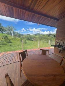 a wooden table and chairs on a deck with a view at Vila do Sossego in São Bento do Sapucaí