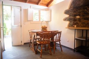 a dining room with a wooden table and chairs at Faja dos Padres in Ribeira Brava