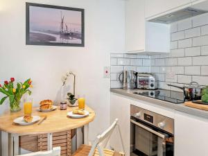 a kitchen with a wooden table with food on it at 2 Bed in Holt oc-78478 in Blakeney