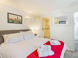 a bedroom with a white bed with towels on a red blanket at 2 Bed in Holt oc-78478 in Blakeney