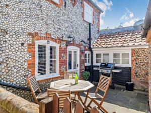 a patio with a table and chairs in front of a building at 2 Bed in Holt oc-78478 in Blakeney