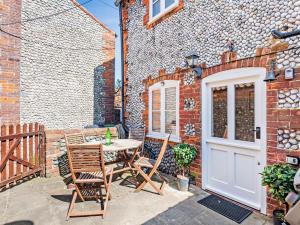 a patio with a table and chairs in front of a building at 2 Bed in Holt oc-78478 in Blakeney +9 photos
