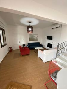 a living room with a blue couch and red chairs at My Olive Tree House in Kalamata
