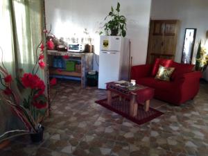 a living room with a red couch and a white refrigerator at YayazNature Lodge in Grecia