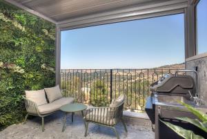 a patio with a table and chairs and a grill at Nof Yareach - נוף ירח in Safed