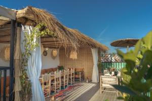 a patio with a table and a straw umbrella at Riad Dar Lamia Marrakech Médina in Marrakesh