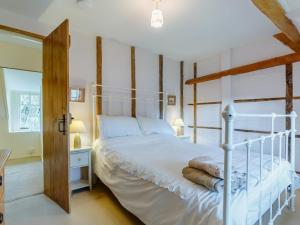 a bedroom with a white bed with a wooden frame at 3 Bed in Dorchester oc-dc089 in Whitcombe