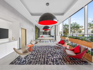 a living room with chairs and a red lamp at ibis Styles Dubai Airport Hotel in Dubai