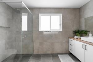 a bathroom with a shower and a sink at Misons Guesthouse in Mollymook +3 photos