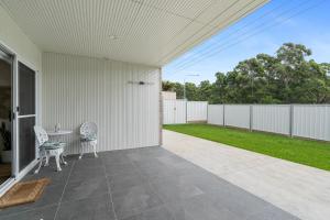 a patio with two chairs and a table at Misons Guesthouse in Mollymook