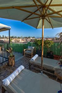 a patio with tables and an umbrella on a deck at Riad Dar Lamia Marrakech Médina in Marrakesh +30 photos