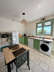 a kitchen with green cabinets and a table in it at Gîte Ti Volkan in Saint-Claude