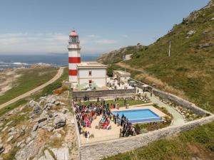 a group of people standing in front of a lighthouse at Hotel Boutique Faro Silleiro in Baiona