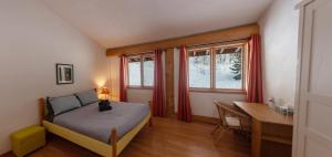 a bedroom with a bed and a desk and a window at Williston Lake Resort in Hudson Hope
