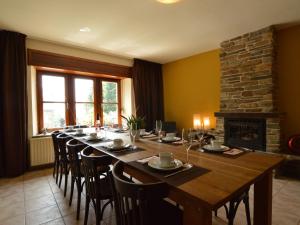uma sala de jantar com uma mesa longa e uma lareira em Cozy Holiday Home in Odeigne with Sauna em Odeigne