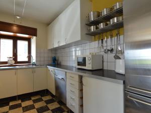 uma cozinha com um lavatório e um micro-ondas em Cozy Holiday Home in Odeigne with Sauna em Odeigne