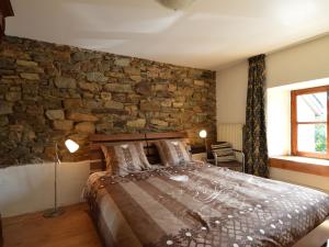 um quarto com uma parede de pedra e uma cama em Cozy Holiday Home in Odeigne with Sauna em Odeigne