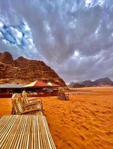 two chairs sitting on a beach in the desert at Rum Red Sand Luxury Camp & Jeep Tours in Wadi Rum