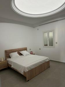 a bedroom with a large bed in a white room at Les jardins de Sara in Mellita +17 photos